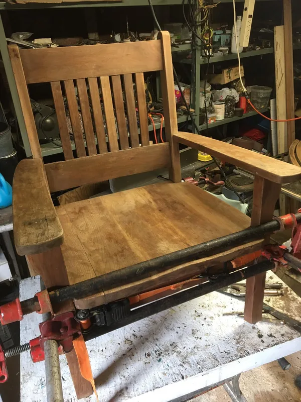 Wooden armchair held in clamps on the workbench