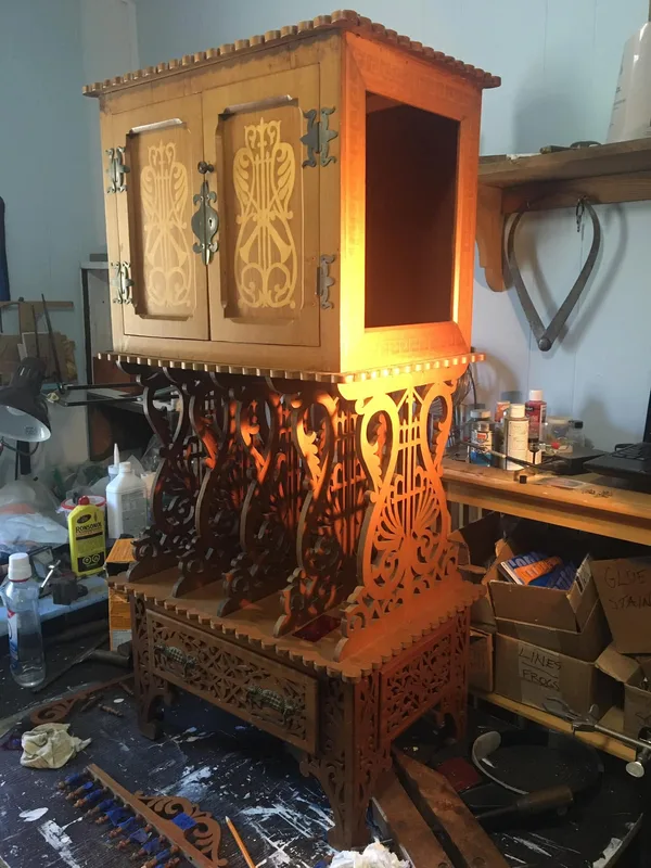 Decorative wooden cabinet with intricate fretwork in Peter’s workshop