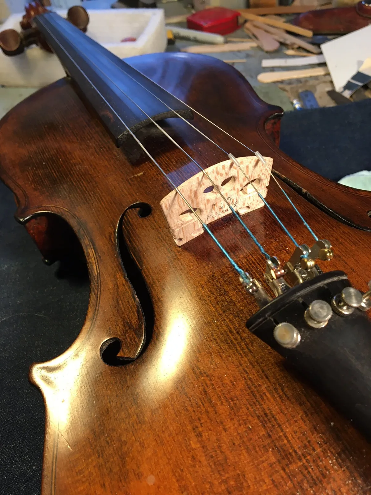 Close view of a violin bridge, strings and fine tuners