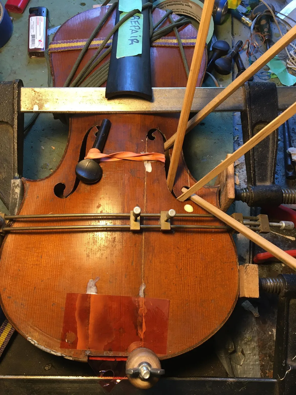 Violin supported with clamps during a crack repair