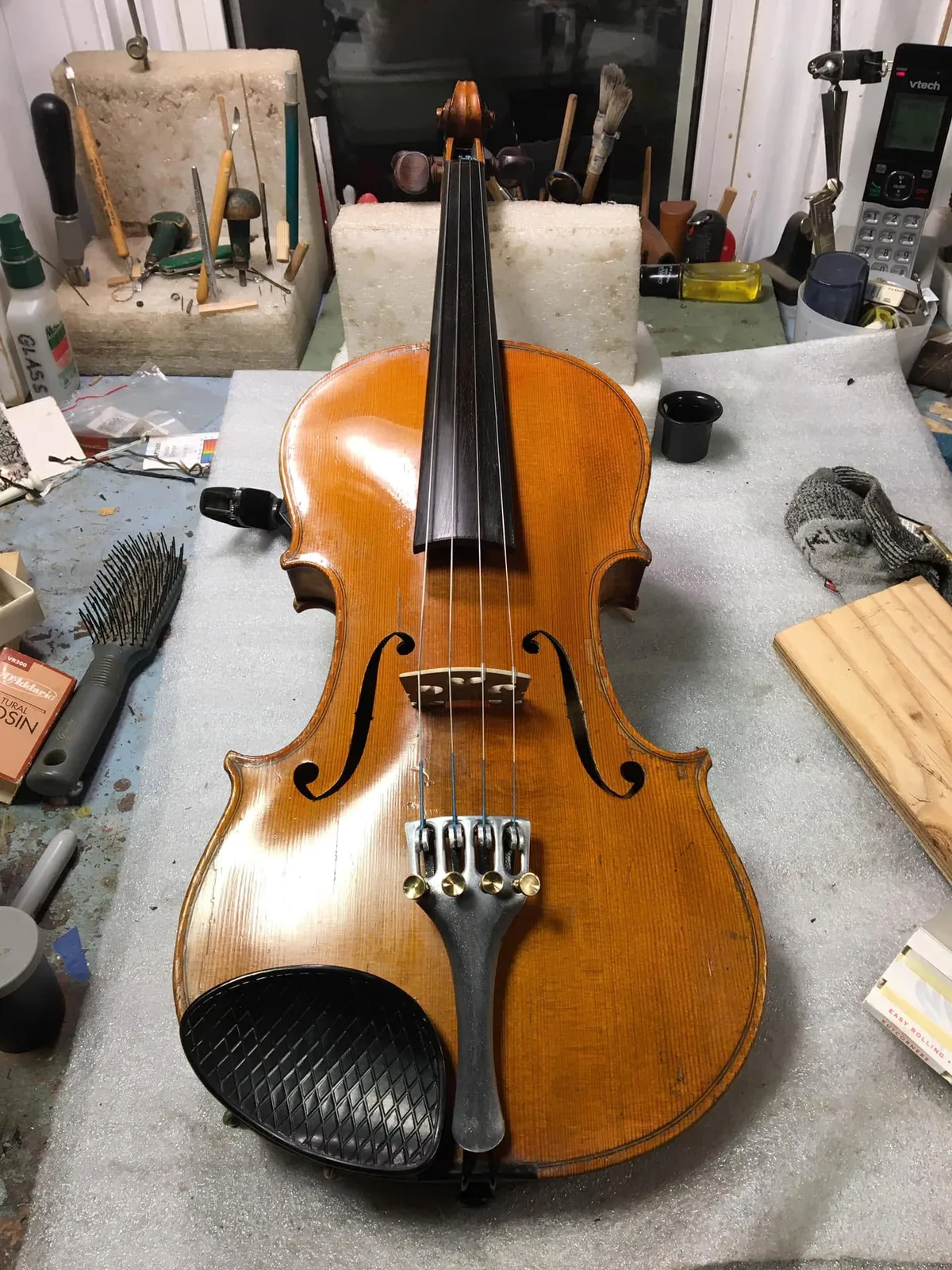 Assembled violin with strings, bridge and tailpiece on Peter’s workbench